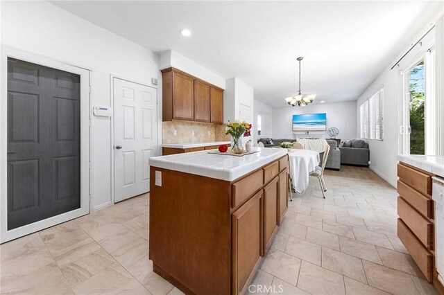 15216 Masline St, Baldwin Park, CA 91706 - kitchen with tile counters, a chandelier, tasteful backsplash, open floor plan, and brown cabinetry