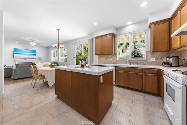 15216 Masline St, Baldwin Park, CA 91706 - kitchen featuring white appliances, decorative backsplash, brown cabinets, a center island, and recessed lighting