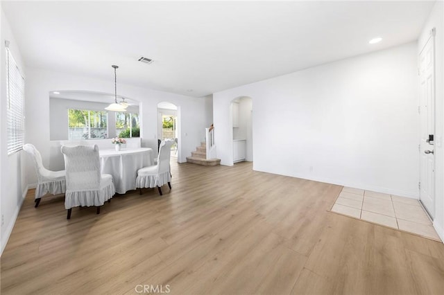 15216 Masline St, Baldwin Park, CA 91706 - dining space featuring arched walkways, light wood finished floors, and stairway