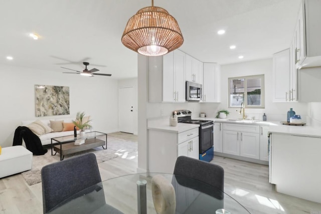 3535 Monroe Ave Unit 5, San Diego, CA 92116 - kitchen featuring stainless steel appliances, open floor plan, light wood finished floors, white cabinetry, and recessed lighting