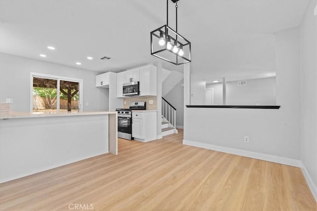 37727 Dixie Dr, Palmdale, CA 93550 - kitchen with appliances with stainless steel finishes, white cabinets, light wood-type flooring, light countertops, and recessed lighting