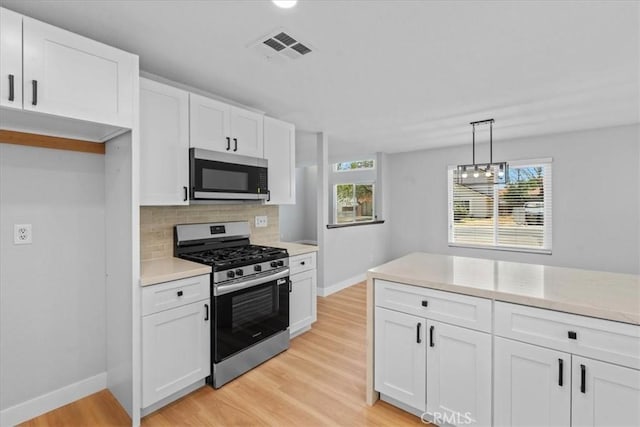 37727 Dixie Dr, Palmdale, CA 93550 - kitchen featuring stainless steel appliances, white cabinetry, decorative backsplash, light wood-type flooring, and light countertops