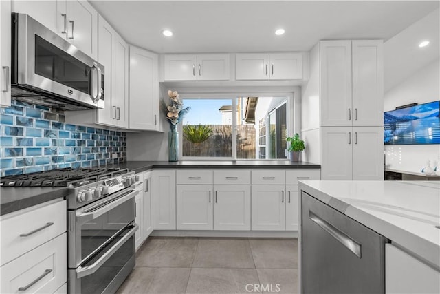 25891 Pinewood Ln, Laguna Hills, CA 92653 - kitchen with stainless steel appliances, tasteful backsplash, white cabinets, light tile patterned floors, and recessed lighting