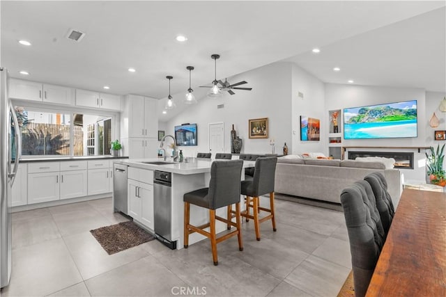 25891 Pinewood Ln, Laguna Hills, CA 92653 - kitchen featuring recessed lighting, appliances with stainless steel finishes, white cabinets, vaulted ceiling, and an island with sink