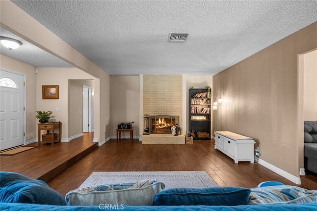 44112 Precise St, Lancaster, CA 93536 - living area featuring wood-type flooring, a textured ceiling, a fireplace, and built in features