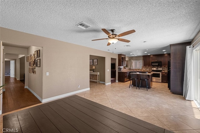 44112 Precise St, Lancaster, CA 93536 - living area featuring a ceiling fan, a textured ceiling, and light tile patterned floors