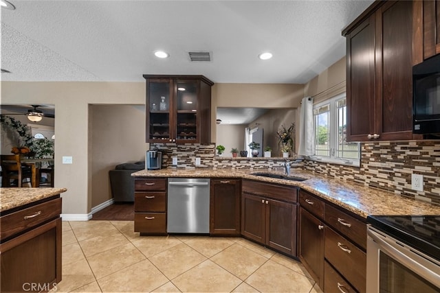 44112 Precise St, Lancaster, CA 93536 - kitchen featuring appliances with stainless steel finishes, tasteful backsplash, ceiling fan, dark brown cabinets, and glass insert cabinets
