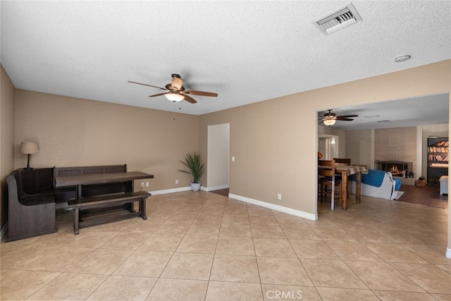 44112 Precise St, Lancaster, CA 93536 - living area with a ceiling fan, a textured ceiling, a large fireplace, and light tile patterned floors