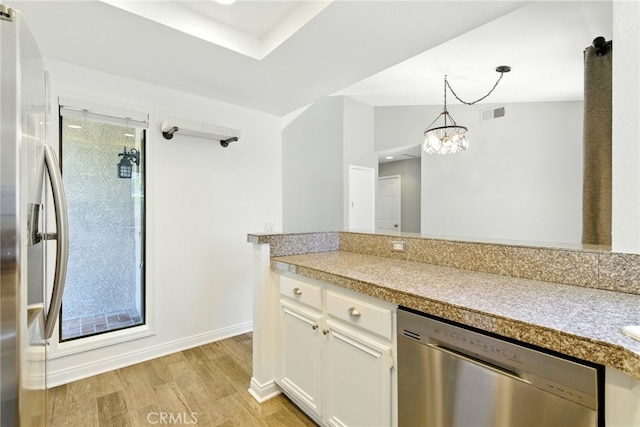 24571 Camden Ct, Laguna Niguel, CA 92677 - kitchen with appliances with stainless steel finishes, tile counters, light wood finished floors, white cabinetry, and decorative light fixtures