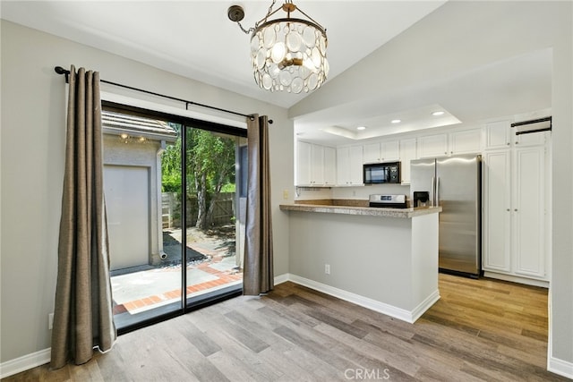 24571 Camden Ct, Laguna Niguel, CA 92677 - kitchen with black microwave, stainless steel fridge, light wood-type flooring, white cabinets, and a chandelier