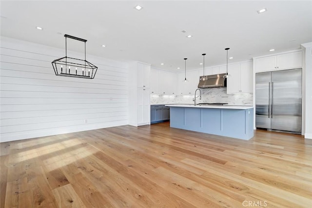 1100 Cypress Ave, Hermosa Beach, CA 90254 - kitchen with stainless steel built in refrigerator, under cabinet range hood, light countertops, tasteful backsplash, and light wood-style flooring