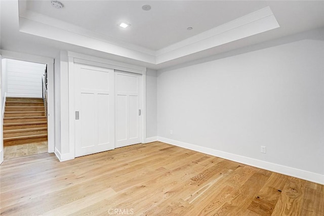 1100 Cypress Ave, Hermosa Beach, CA 90254 - unfurnished bedroom featuring a tray ceiling, light wood-style floors, and a closet