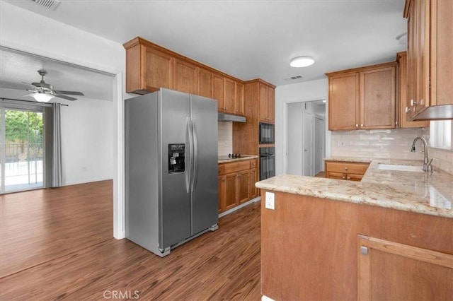 5495 N Callisch Ave, Fresno, CA 93710 - kitchen featuring black appliances, wood finished floors, a peninsula, and tasteful backsplash