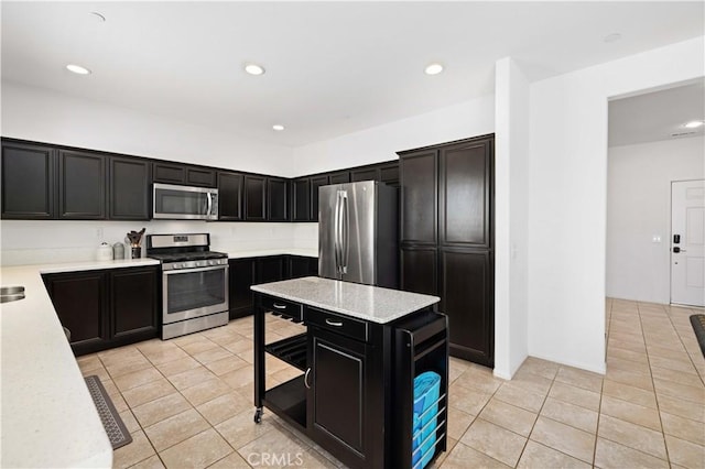 3660 Half Dome Ave, Rosamond, CA 93560 - kitchen with stainless steel appliances, dark cabinets, light tile patterned flooring, recessed lighting, and a center island