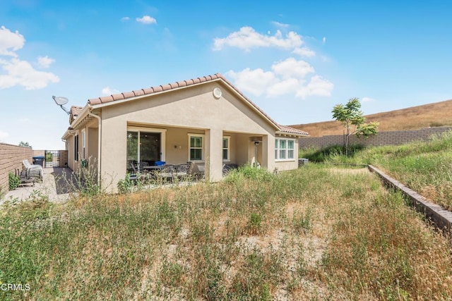 566 Purple Sage Ln, Simi Valley, CA 93065 - rear view of property featuring stucco siding, a tile roof, and a patio