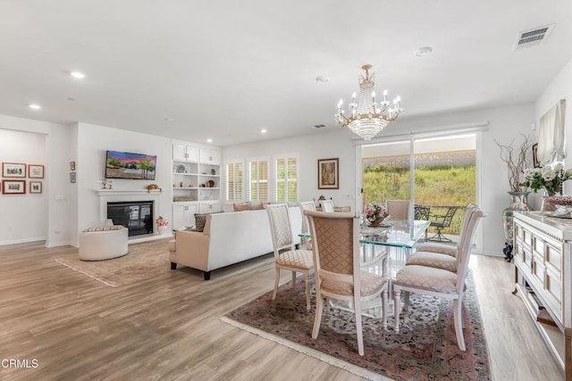 566 Purple Sage Ln, Simi Valley, CA 93065 - dining area featuring recessed lighting, light wood-style flooring, a chandelier, a glass covered fireplace, and built in features