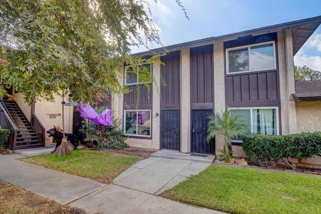 10135 Peaceful Ct, Santee, CA 92071 - view of front of house with a front lawn, stairway, board and batten siding, and stucco siding