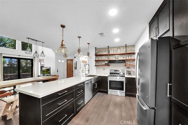 645 Springbrook, Irvine, CA 92614 - kitchen with appliances with stainless steel finishes, open shelves, backsplash, light countertops, and a peninsula