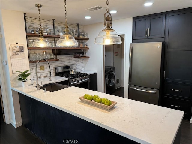 645 Springbrook N Unit 21, Irvine, CA 92614 - kitchen with appliances with stainless steel finishes, washer / clothes dryer, open shelves, backsplash, and light stone countertops