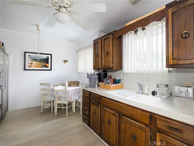 512 Lomita St, El Segundo, CA 90245 - kitchen featuring ceiling fan, light countertops, tasteful backsplash, light wood-style flooring, and brown cabinets