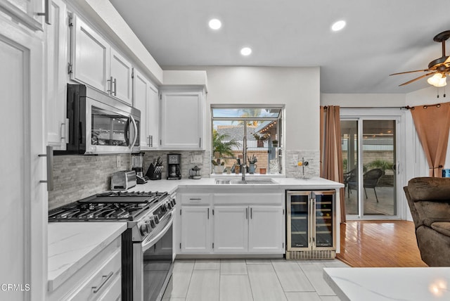 1306 Bluejay St, Fillmore, CA 93015 - kitchen with appliances with stainless steel finishes, beverage cooler, a ceiling fan, tasteful backsplash, and light tile patterned flooring