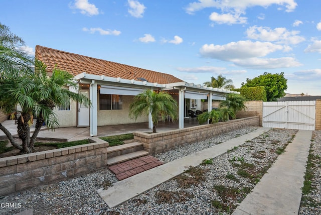 1306 Bluejay St, Fillmore, CA 93015 - view of front of home with a gate, a tiled roof, a patio, and stucco siding