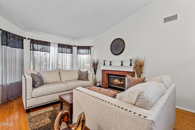 1306 Bluejay St, Fillmore, CA 93015 - living room featuring wood finished floors, lofted ceiling, a fireplace, and baseboard heating