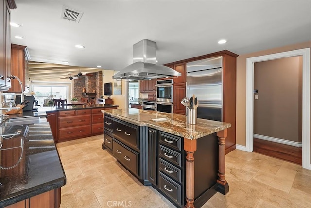 2082 Kaia Ln, Sierra Madre, CA 91024 - kitchen with island exhaust hood, stainless steel double oven, a kitchen island, a ceiling fan, and dark stone counters