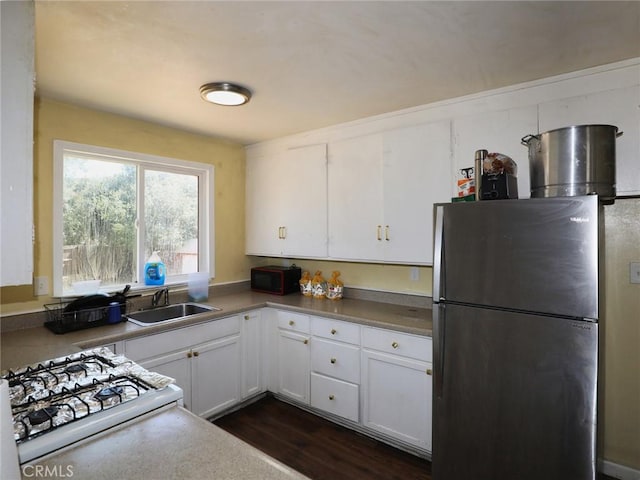 3450 10th St, Clearlake, CA 95422 - kitchen featuring freestanding refrigerator, white cabinets, stove, and dark wood-style flooring