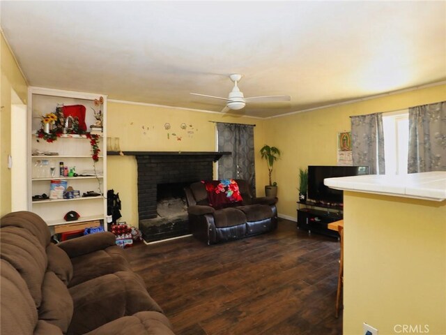 3450 10th St, Clearlake, CA 95422 - living area with dark wood-style floors, a ceiling fan, a brick fireplace, and crown molding