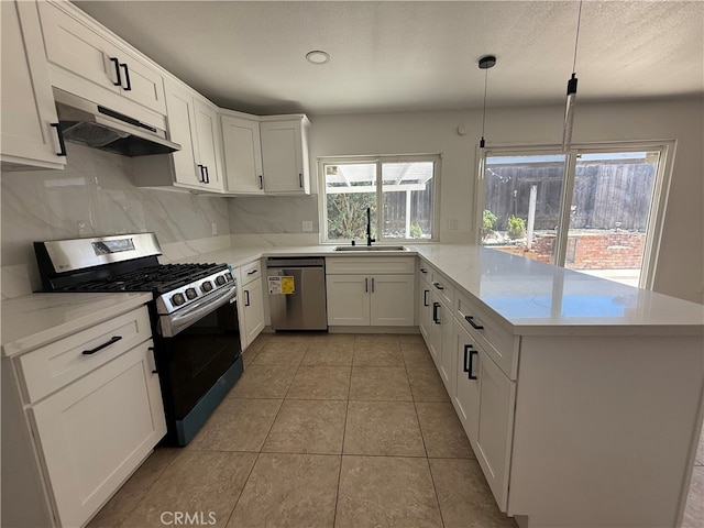 7293 Macy Ct, Riverside, CA 92503 - kitchen with appliances with stainless steel finishes, under cabinet range hood, a peninsula, decorative backsplash, and white cabinets