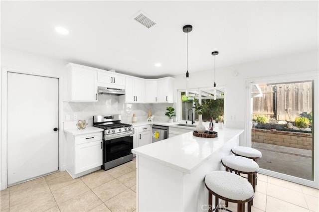 7293 Macy Ct, Riverside, CA 92503 - kitchen featuring appliances with stainless steel finishes, under cabinet range hood, a peninsula, a kitchen bar, and light countertops
