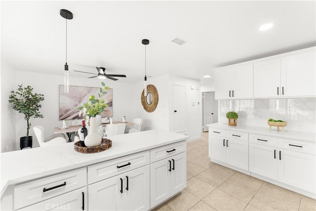7293 Macy Ct, Riverside, CA 92503 - kitchen with light countertops, a ceiling fan, light tile patterned floors, white cabinets, and pendant lighting