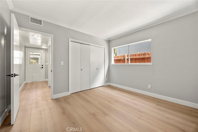 1141 N Palm St, La Habra, CA 90631 - unfurnished bedroom featuring light wood finished floors, a closet, multiple windows, and crown molding