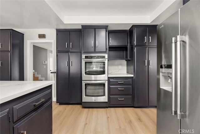 1141 N Palm St, La Habra, CA 90631 - kitchen with appliances with stainless steel finishes, light wood-style floors, open shelves, and light stone counters