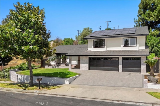 1141 N Palm St, La Habra, CA 90631 - view of front of property featuring a front yard, driveway, an attached garage, roof mounted solar panels, and brick siding