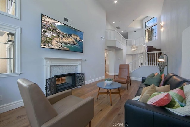 7 Luzern, Mission Viejo, CA 92692 - living room with a high ceiling, wood finished floors, a glass covered fireplace, stairs, and recessed lighting