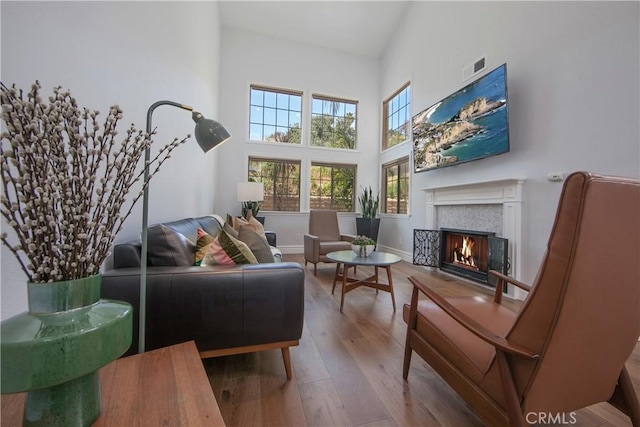 7 Luzern, Mission Viejo, CA 92692 - living room featuring a lit fireplace, wood finished floors, and a towering ceiling