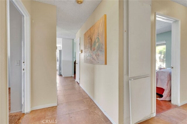 1926 E 7th St, Ontario, CA 91764 - corridor with light tile patterned flooring and a textured ceiling