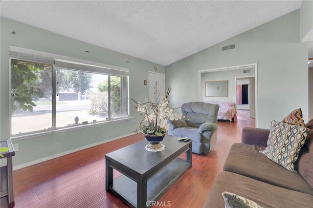 1926 E 7th St, Ontario, CA 91764 - living area with a textured ceiling, vaulted ceiling, and wood finished floors