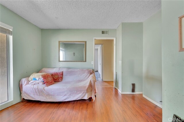1926 E 7th St, Ontario, CA 91764 - bedroom with wood finished floors and a textured ceiling