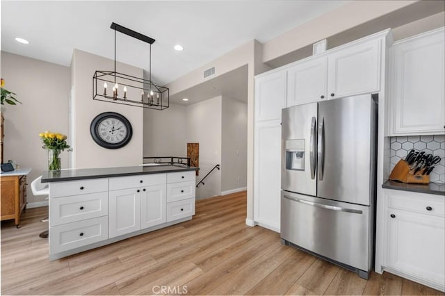 14535 Margate St Unit 13, Sherman Oaks, CA 91411 - kitchen featuring stainless steel fridge with ice dispenser, dark countertops, a chandelier, light wood finished floors, and white cabinets