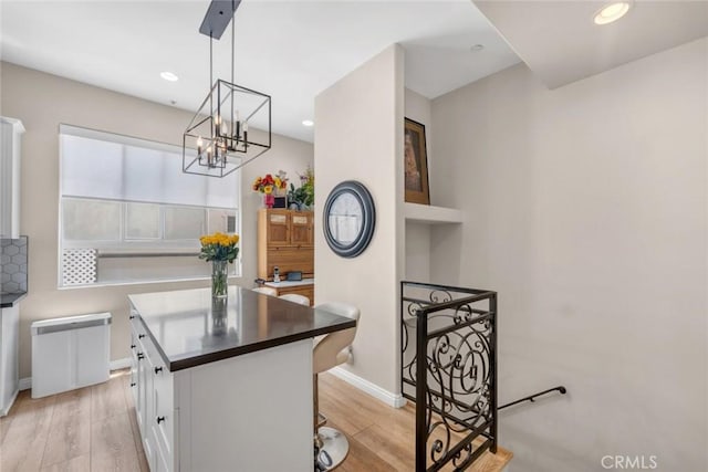 14535 Margate St Unit 13, Sherman Oaks, CA 91411 - kitchen featuring white cabinetry, light wood-type flooring, a chandelier, dark countertops, and recessed lighting