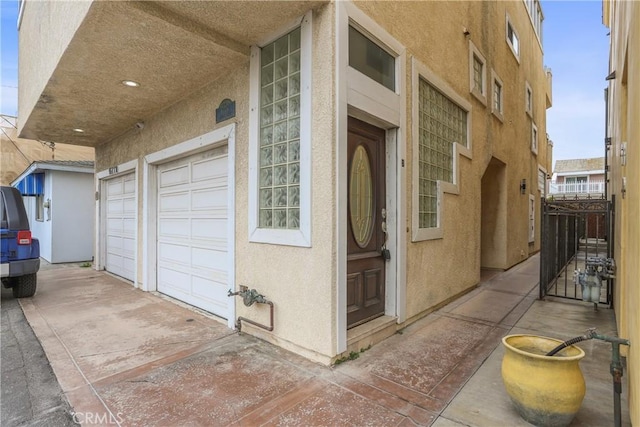 16778 Bayview Dr Unit B, Huntington Beach, CA 92649 - property entrance with a garage, stucco siding, and driveway