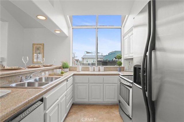 16778 Bayview Dr Unit B, Huntington Beach, CA 92649 - kitchen featuring stainless steel appliances, white cabinets, light countertops, light tile patterned floors, and recessed lighting