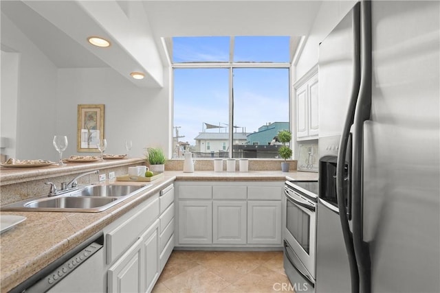 16778 Bayview Dr Unit B, Huntington Beach, CA 92649 - kitchen with appliances with stainless steel finishes, white cabinetry, light countertops, light tile patterned floors, and recessed lighting
