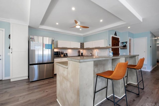 3985 Shenandoah Dr, Oceanside, CA 92056 - kitchen with appliances with stainless steel finishes, a raised ceiling, tasteful backsplash, dark wood-style flooring, and a breakfast bar