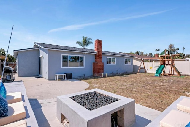 3985 Shenandoah Dr, Oceanside, CA 92056 - back of house with a fire pit, a fenced backyard, a patio, stucco siding, and a playground
