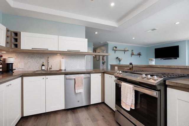 3985 Shenandoah Dr, Oceanside, CA 92056 - kitchen with appliances with stainless steel finishes, a raised ceiling, tasteful backsplash, white cabinets, and wood finished floors