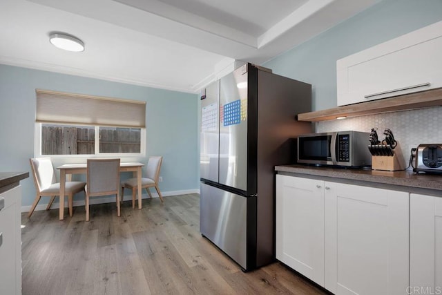 3985 Shenandoah Dr, Oceanside, CA 92056 - kitchen with appliances with stainless steel finishes, light wood finished floors, tasteful backsplash, white cabinets, and crown molding